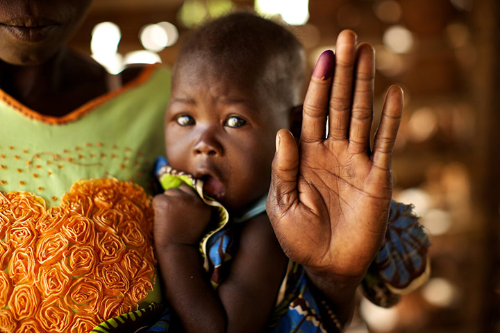 Sudan voters: Hallen Jabe Luka holds up her ink-stained finger to show she voted