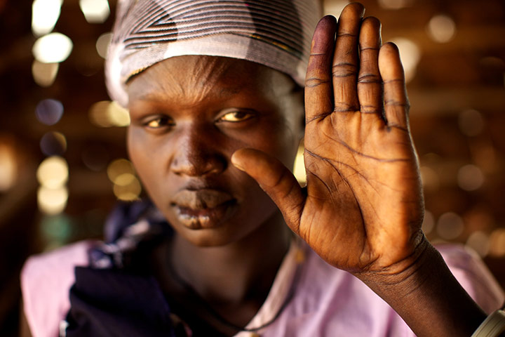 Sudan voters: Mary Ayan holds up her ink-stained finger to show she voted