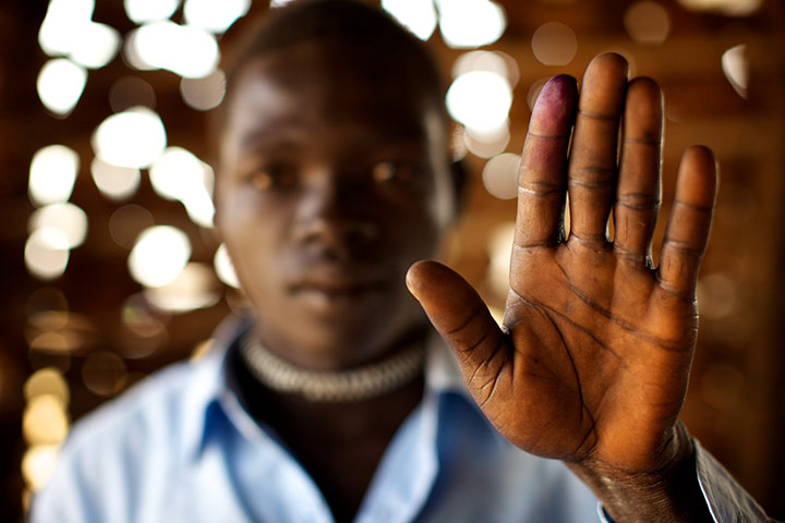 Sudan voters: Richard Wanu holds up his ink-stained finger to show he voted