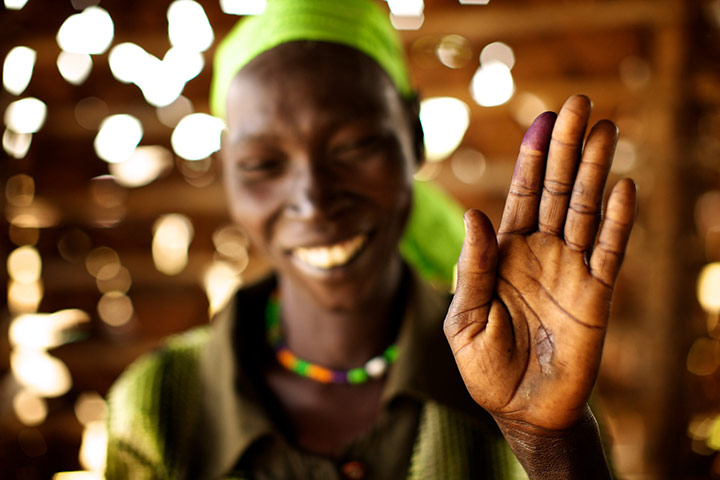 Sudan voters: Lona Bate holds up her ink-stained finger to show she voted
