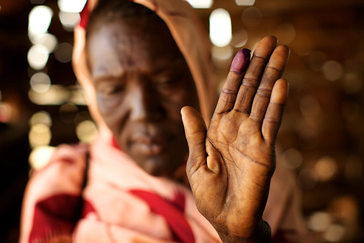 Sudan voters: Mary Khamisa holds up her ink-stained finger to show she voted