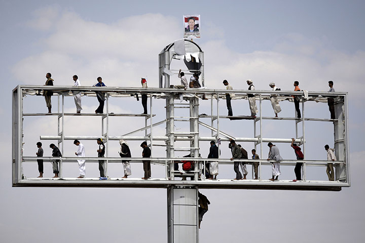 24 in pictures: Protestors pray on a disused billboard in Yemen