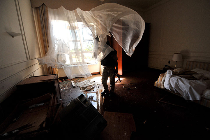 Sirte battles: An NTC fighter inspects a room at ousted Muammar Gaddafi's Sirte palace
