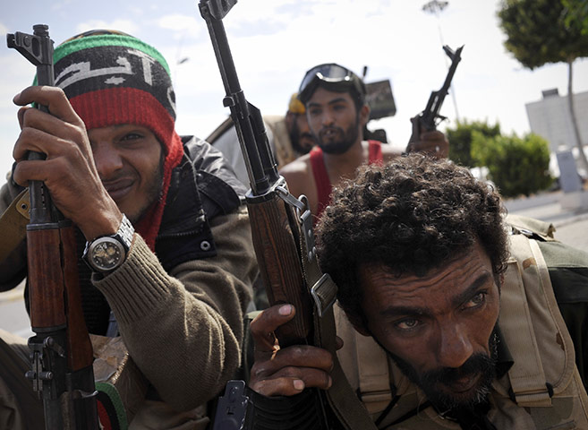 Sirte battles: Libyan revolutionary fighters take cover from sniper fire 
