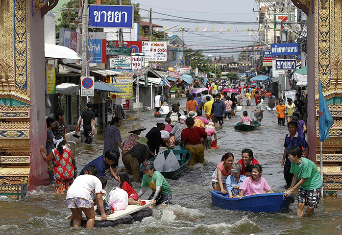 Flooding in Thailand: People make their way through a flooded street