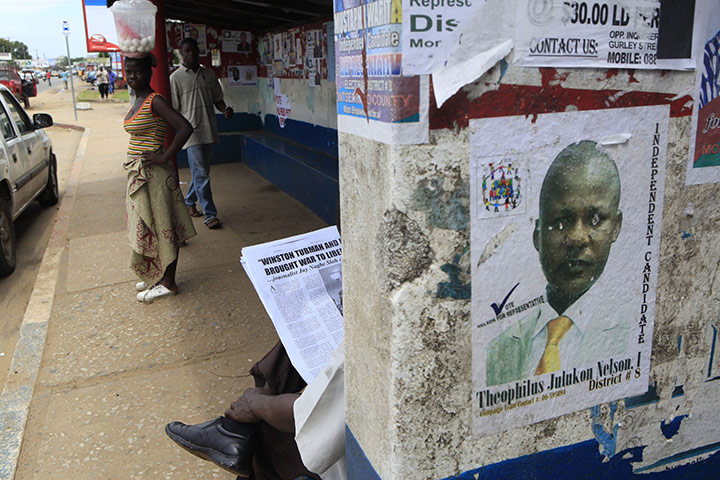 Liberia elections: A man reads a partisan newspaper article