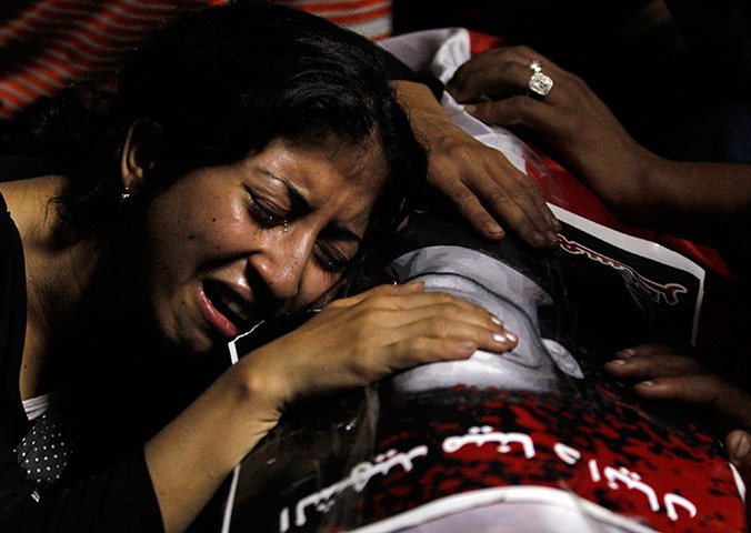 24 hours: Cairo, Egypt: An Egyptian woman mourns on the coffin of Mina Daniel
