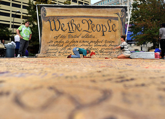 24 hours: Washington, DC: People sign a huge banner during the Occupy DC protest