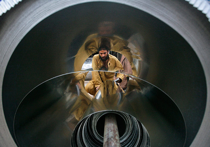 24 hours: Quetta, Pakistan: A man is framed through an aluminium roll