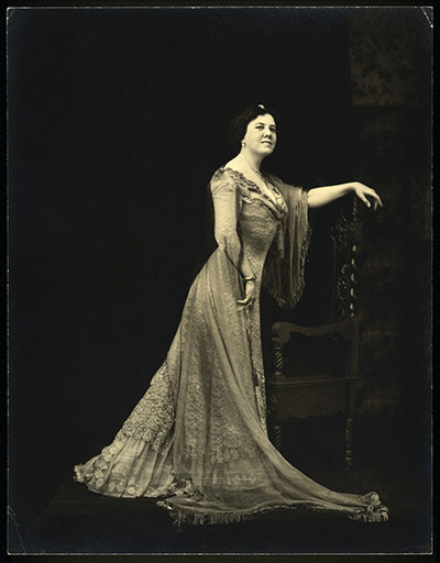 The history of lace: A woman posing in full-length dress, 1890s