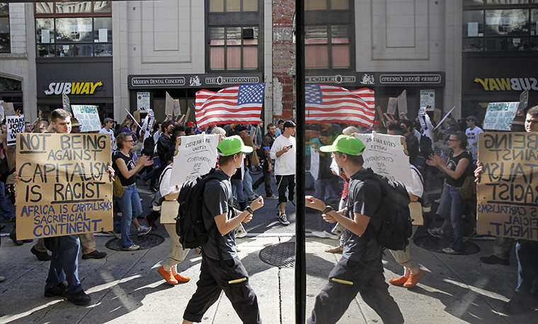 Occupy protests: Philadelphia: People hold signs and are reflected during their march
