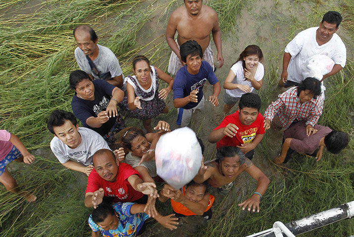 Thailand floods: Residents catch relief goods distributed from a helicopter in Ayutthaya