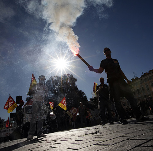 24 hours: Nice, France: A man holds a flare during a national day of protest 