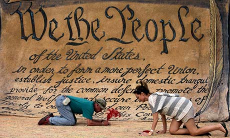 People sign a huge copy of the US constitution at the Occupy DC camp in Washington