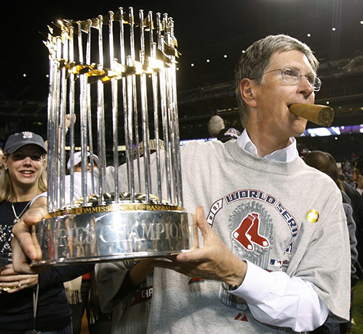 John Henry Timeline: Boston Red Sox principal owner John Henry holds the World Series trophy