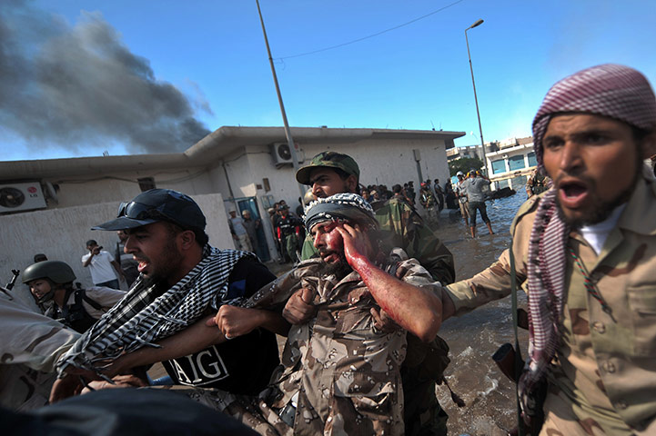 Sirte street battles: NTC fighters evacuate a wounded comrade after he was shot by a sniper 