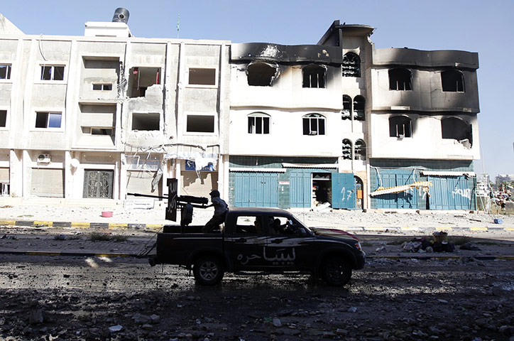 Sirte street battles: An anti-Gaddafi fighter fires a heavy machine gun during clashes