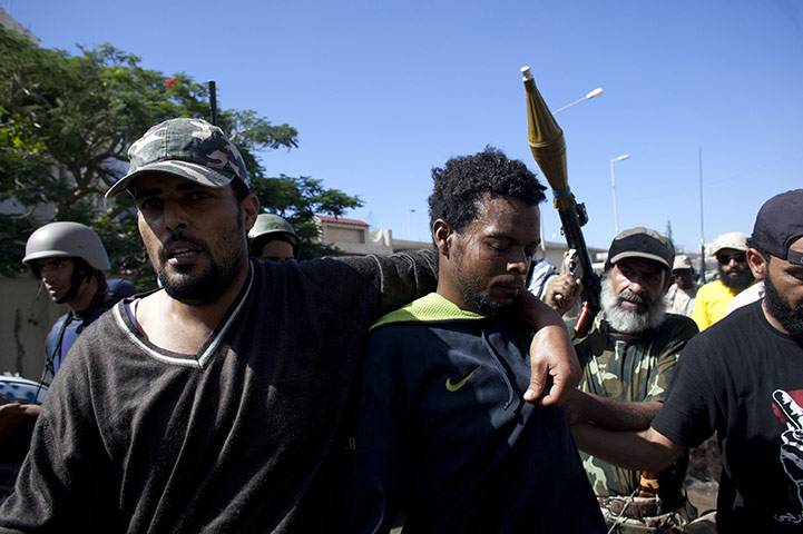 Sirte street battles: An alleged member of the pro-Gaddafi forces is captured during a battle 