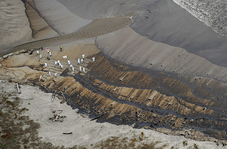 Rena oild spill: New Zealand army soldiers  clear the oil from Papamoa Beach, New Zealand