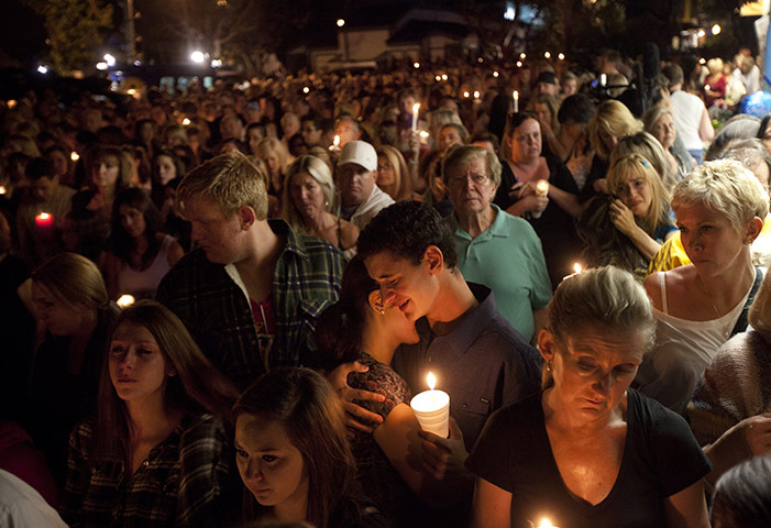 24 hours in pictures: Seal Beach, US: Mourners pay their respects during a vigil