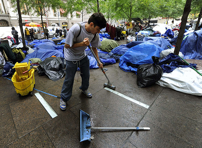 Occupy Wall Street: A protester sweeps the pavement