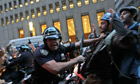 A police officer shoves a protester affiliated with the Occupy Wall Street protests