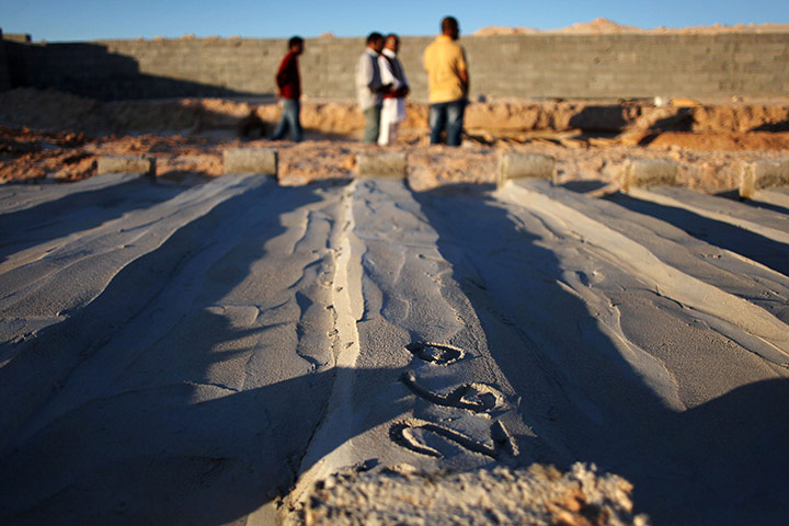 24 hours: Misrata, Libya: Men walk through a graveyard for Gaddafi loyalists