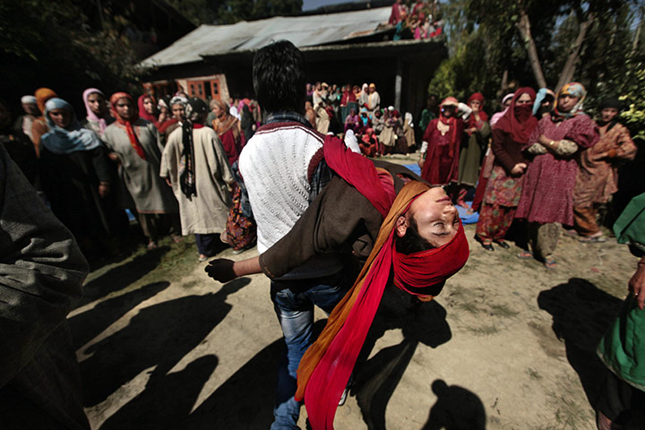 24 hours: Ghariand, India: A man carries a relative of Sajjad Ahmad Parray