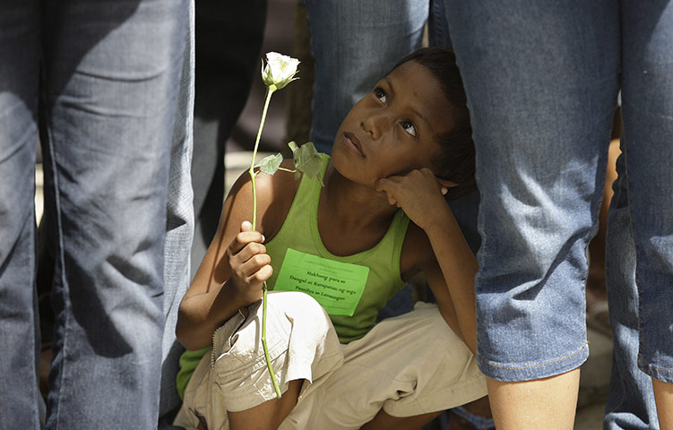 24 hours: Manila, Philippines: A Filipino street child holds a white rose