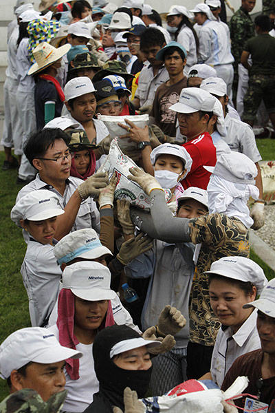 Thailand flooding: Workers build a barrier to protect their factory from floods