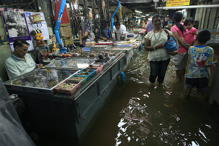 Thailand flooding: Customers visit a flooded amulet market nearby Chao Phrya river