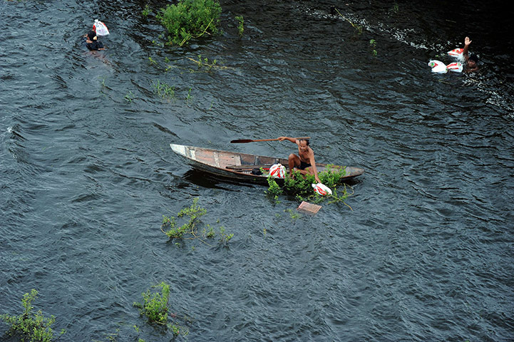 Thailand flooding: Villagers collect bags containing relief material