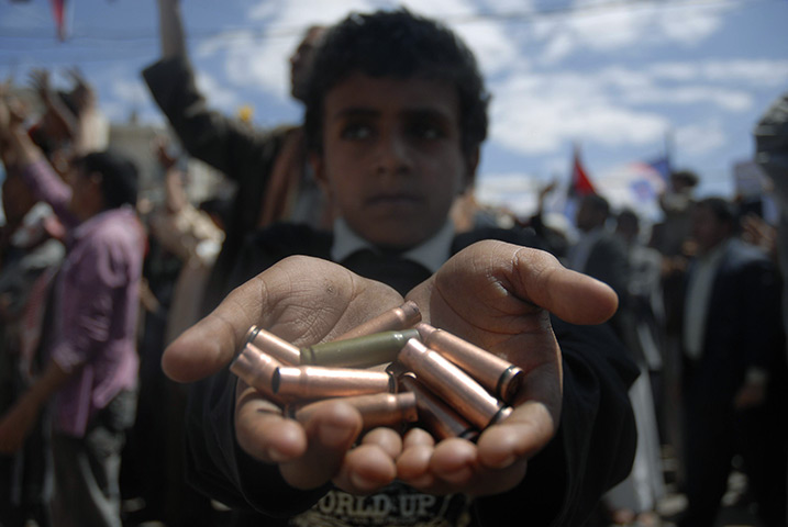 24 hours: Sana'a, Yemen: A boy displays spent bullet cases fired during a demo