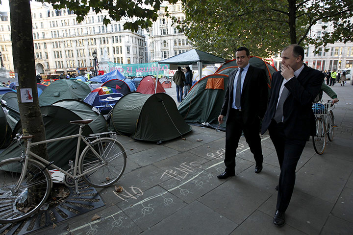 Occupy London: businessmen walk past tents