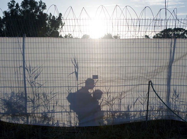 gilad shalit release: Israeli soldiers patrol behind a fence at Tel Nof air force base