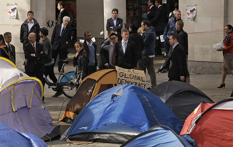 Occupy London: Business people look at tents at Occupy London Stock Exchange