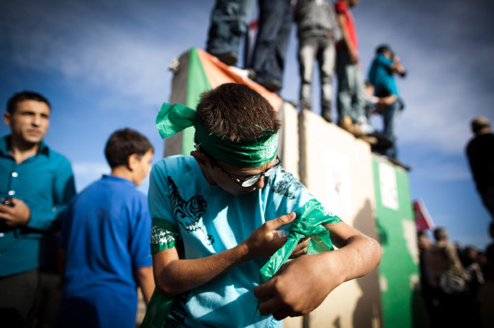 24 hours in pictures: Ramallah, West Bank:  A Palestinian boy adjusts one of his Hamas armbands