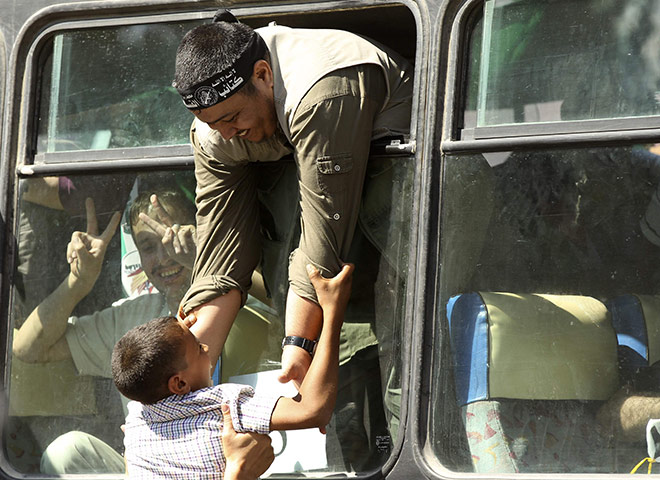 Shalit release: A freed Palestinian a lifts a boy at the Rafah crossing border
