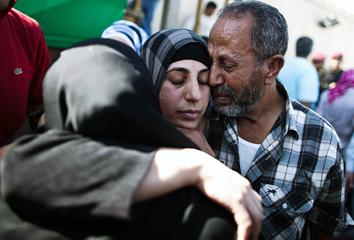 Shalit release: A Palestinian prisoner hugs relatives after arriving in Mukata 