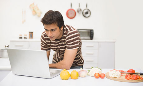 Man looking at a recipe on a laptop in the kitchen