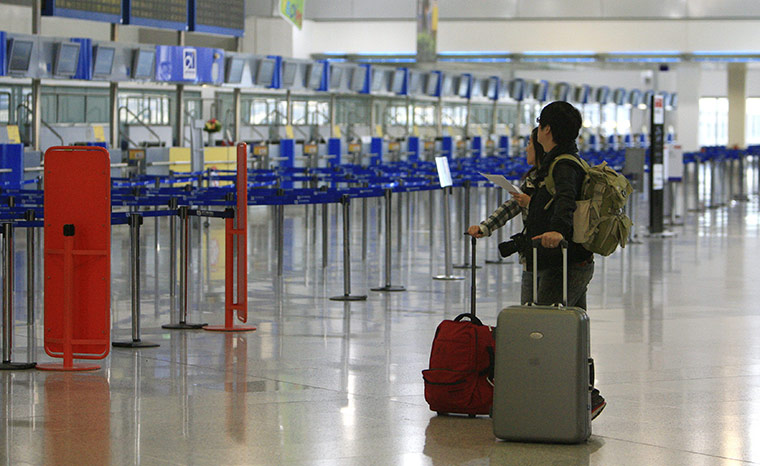 Greece strikes & protests: Tourists check the departure board  at the Athens International Airport