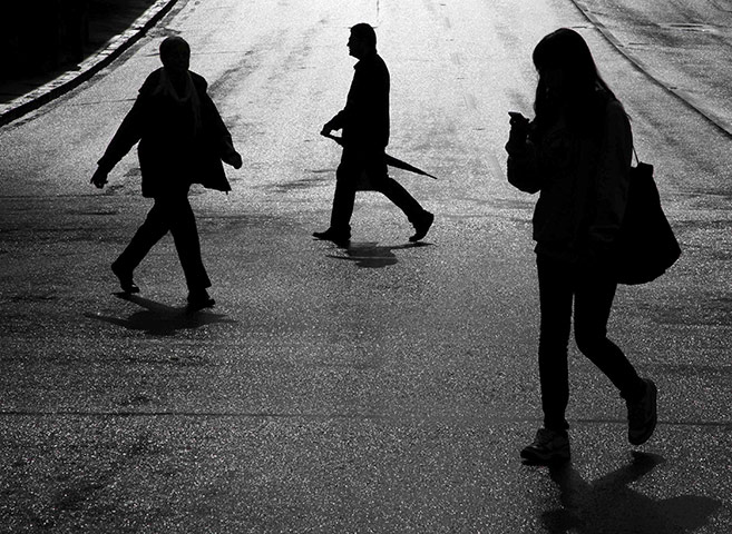 24 hours in pictures: People cross a street after a rain shower in Auckland