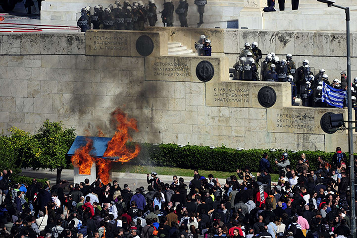 Greece strikes & protests: Protesters burn a guard box in front of the Greek parliament in Athens 