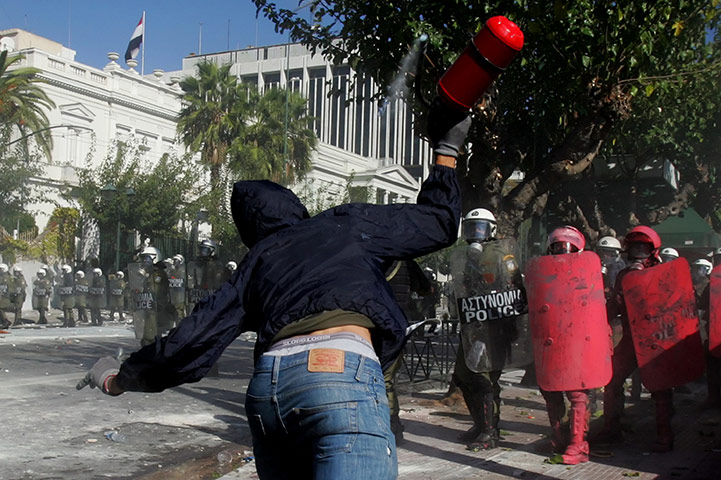 Greece strikes & protests: A demonstrator clashes with police