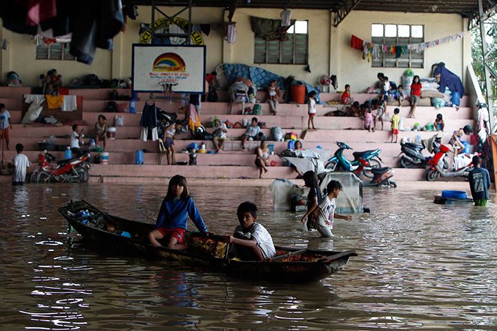 24 hours in pictures: Filipino villagers wade in floodwaters inside an evacuation centre