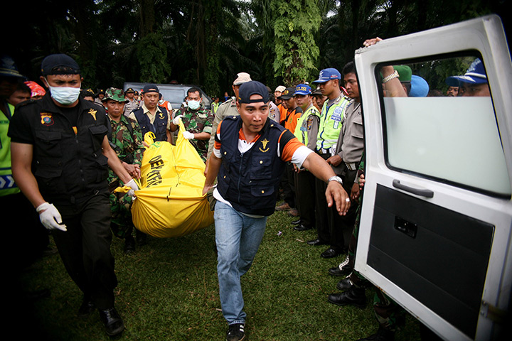 24 hours in pictures: Indonesian rescue team carry the body of a plane crash victim