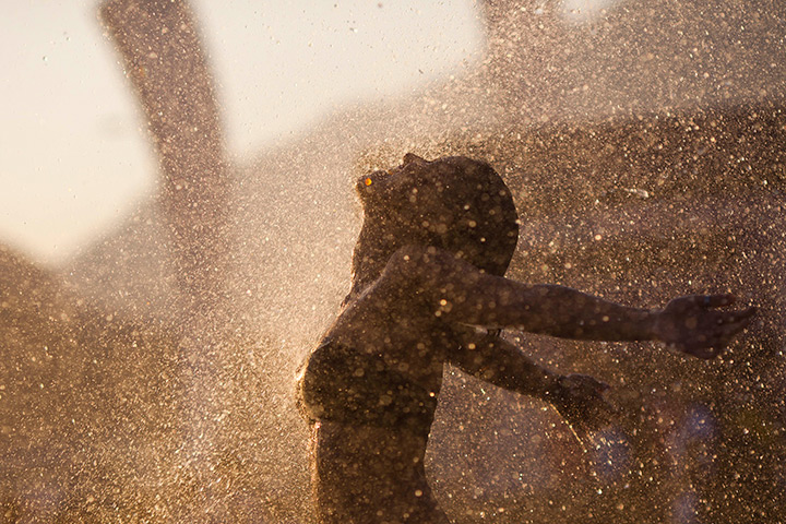 24 hours in pictures: A woman walks into a spray of water in Rio