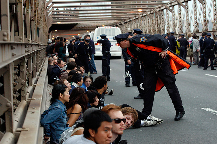 24 hours in pictures: A police officer leans over to talk to a protester on the Brooklyn Bridge