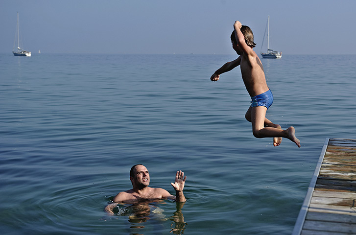 24 hours in pictures: Father and son enjoying the warm weather at Bellevue Beach, Copenhagen