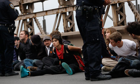 Protesters sit on the road in plastic handcuffs after being arrested on the Brooklyn Bridge during an Occupy Wall Street march Photograph: Jessica Rinaldi/Reuters